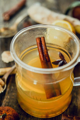 Vitamin tea with lemon and honey, ginger and spices on wooden background . The concept of spring beriberi and colds.
