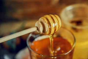 Fototapeta na wymiar honey on a wooden spoon for honey, dripping from a spoon. Close up.