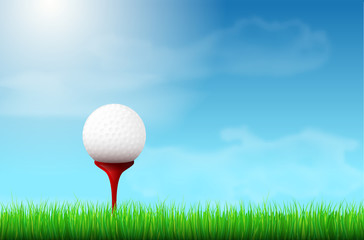 Golf ball on red tee, grass and blue sky