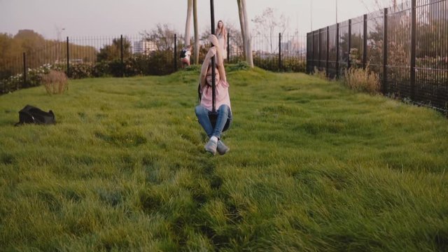 Little European girl on a playground zip wire. Slow motion. Happy female child rides a long zipline swing. Childhood.