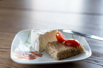 A piece of soft cheese and  tomatos