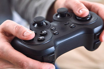 man holding a joystick controllers while playing a video games at home