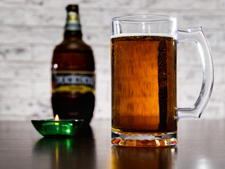 A beer mug and a bottle on the table.