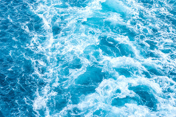 Naklejka na ściany i meble water foam from trail of cruise ship against blue sea wave for background