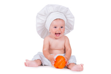 A funny little girl in a chef's clothes is eating pepper.