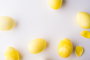 Yellow eggs and flower petals on a white background.