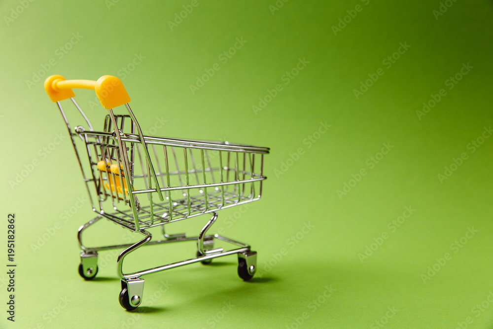 Wall mural close up of supermarket grocery push cart for shopping with black wheels and yellow plastic elements