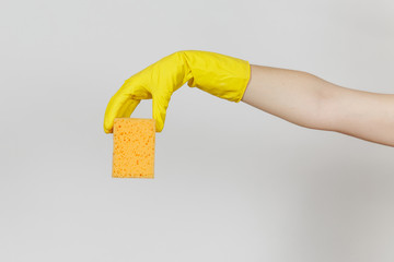 Close up of female hand in yellow gloves horizontal holds yellow-orange sponge for cleaning and...
