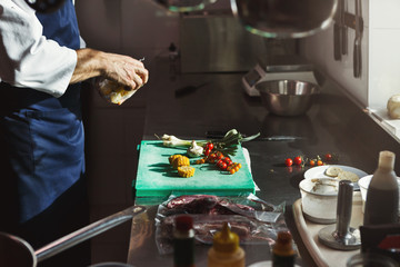 Chef cutting fresh vegetables for salad