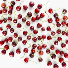 Naklejka na ściany i meble Fresh red cherries lay on white isolated background with copy space. Background of cherries. Ripe cherry on a white background. Cherries with copy space for text. Top view. 