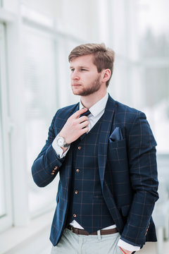 pensive newcomer businessman in a business suit stands near the 