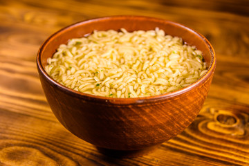Ceramic bowl with prepared instant noodles on wooden table