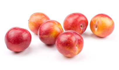Six plums red orange stack isolated on white background.