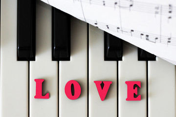Piano keys closeup with the letters love and the heart. The original art image with valentine.