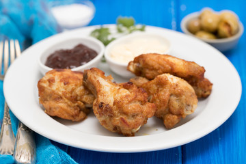 fried chicken with sauces on white plate