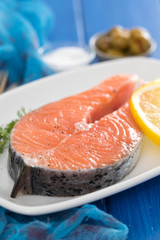 raw salmon with lemon on white dish