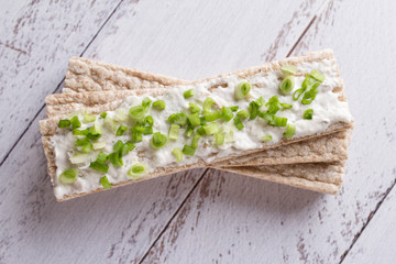 Obraz na płótnie Canvas Rye crispbread with soft cheese and fresh herbs. Dietary vegetarian sandwich.Crispy dietary fitness bread. Food for weight loss space for text