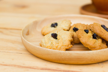 cookies with raisins on round plate and brown wooden table