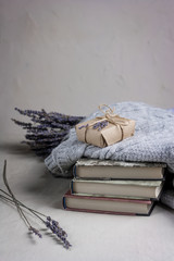 gray cozy knitted sweaters and lavender on a heap books
