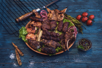 Grilled different meat with vegetable on a blue wooden background