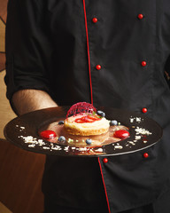 Lemon cheesecake with berry spheres served at modern restaurant