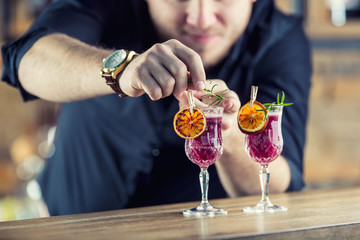 Barman in pub or restaurant  preparing a cocktail drink