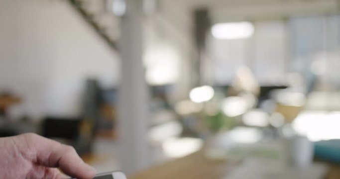 Smarthome technology. Man closing rolling shutter with Smartphone