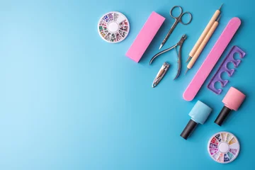 Wall murals Pedicure A set of cosmetic tools for manicure and pedicure on a blue background. Gel polishes, nail files and clippers, top view