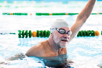 Senior man in an indoor swimming pool.
