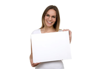 Fototapeta premium Hübsche Frau mit Brille lacht und hält eine weisse Leinwand in ihren Händen