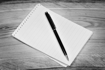 Blank notepad with pen on a wooden office table