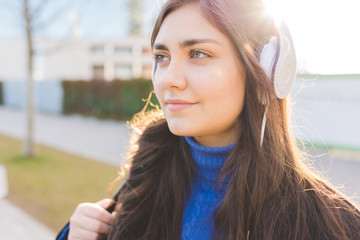 portrait young woman outdoor in the city listening music headphones - music, relaxing, enjoyment...