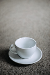 Empty white coffee cup on gray background. Copy space.