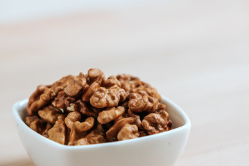 Close-up image of white bowl with walnuts. Copy space.