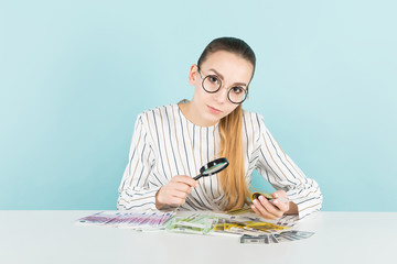 Attractive woman with cash and magnifying glass