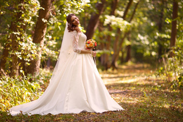 Bride at wedding Day walking Outdoors on nature. Happy Newlywed woman embracing in green park