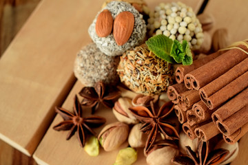 Fototapeta premium Sweets with different sprinkles, cinnamon, anise stars, mint and pistachio nuts on wooden boards