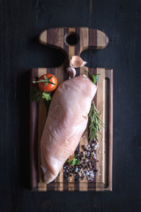 Raw chicken file on wooden cutting board