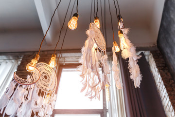 Decorative dream catcher in home interior with edison lamps