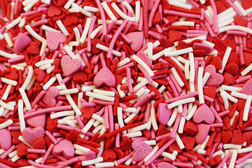 colored sweet sprinkled icing for Easter red and pink color in the shape of a heart close-up. Valentine's Day.