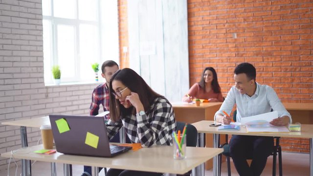a group of young students sitting in the classroom and listening attentively to the teacher. University or school. A group of people mixed races. 4k