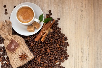 Coffee cup, cinnamon, star anise and coffee beans on light background. Top view