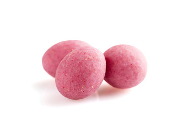 Heap of pink sugared almonds dragees isolated on white background