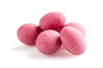Heap of pink sugared almonds dragees isolated on white background
