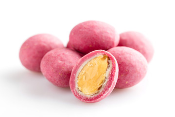 Heap of pink sugared almonds dragees isolated on white background
