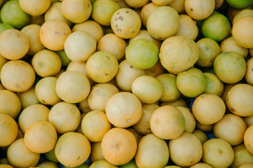 lemons and lime in a large wicker basket on the market in India