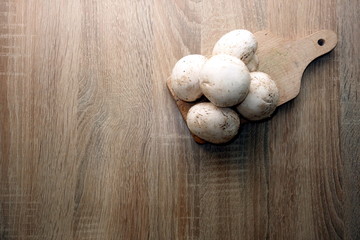 Fresh champignon mushrooms on rustic wooden table, space for a   text