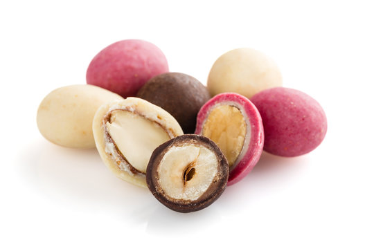 Heap of sugared almonds and hazelnuts dragees in chocolate isolated on white background