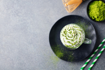 Matcha green tea latte with whipped cream. Top view. Copy space.