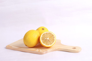 Lemon on cutting board isolated on white background
